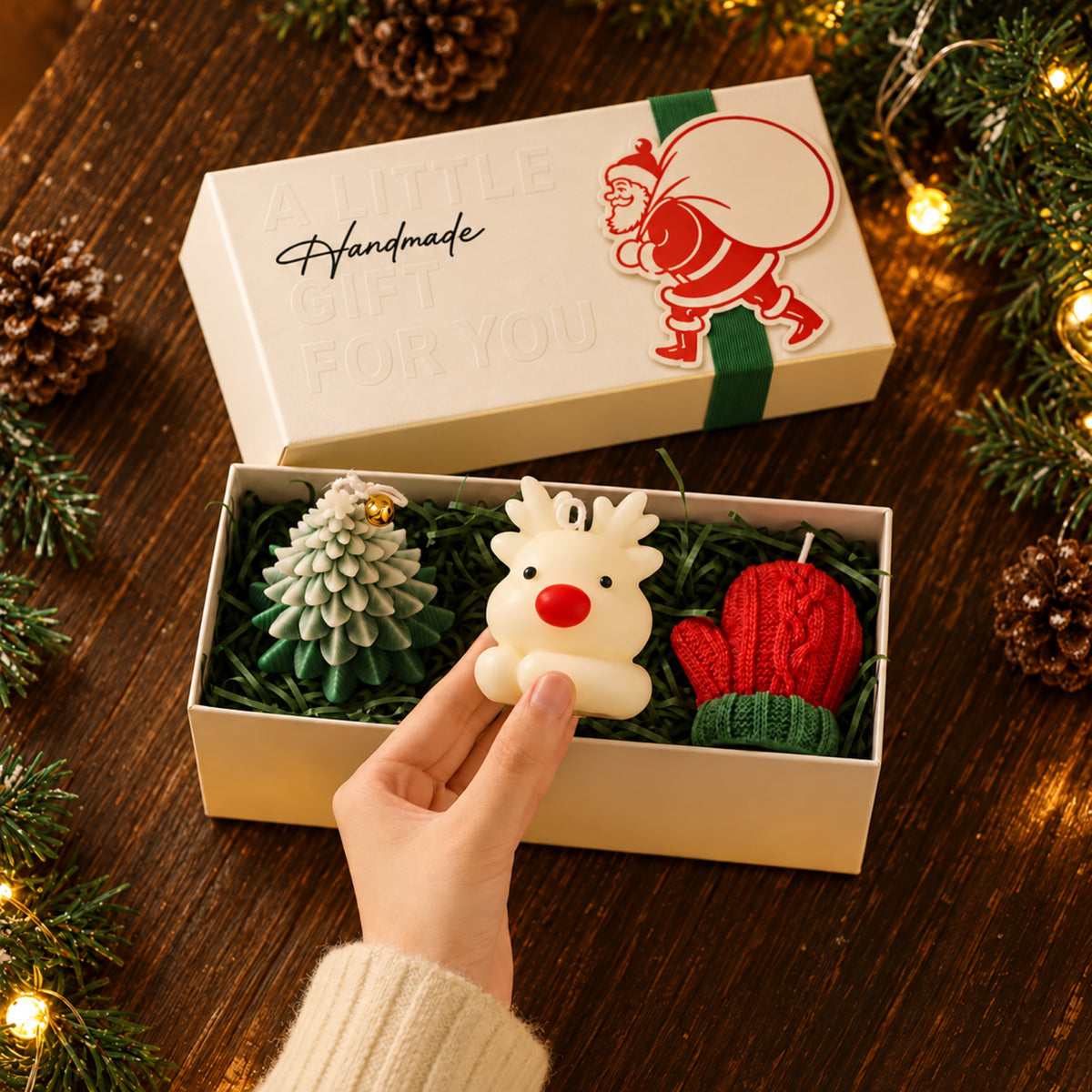 Rendierkaars in de hand naast de geopende geschenkdoos